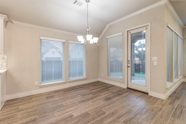 unfurnished dining area featuring a notable chandelier, ornamental molding, and lofted ceiling