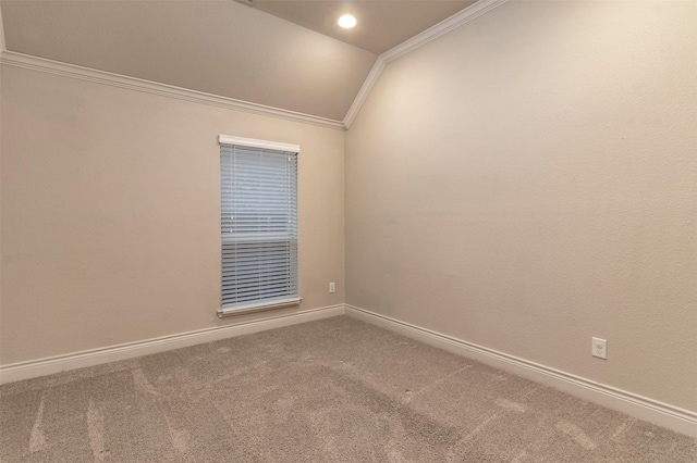 spare room featuring carpet flooring, vaulted ceiling, and crown molding