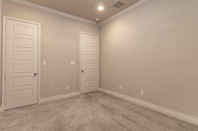 empty room featuring light colored carpet and ornamental molding