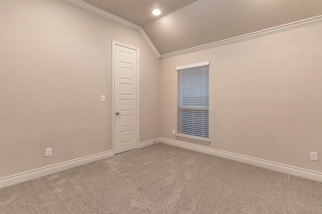 carpeted spare room with vaulted ceiling and crown molding