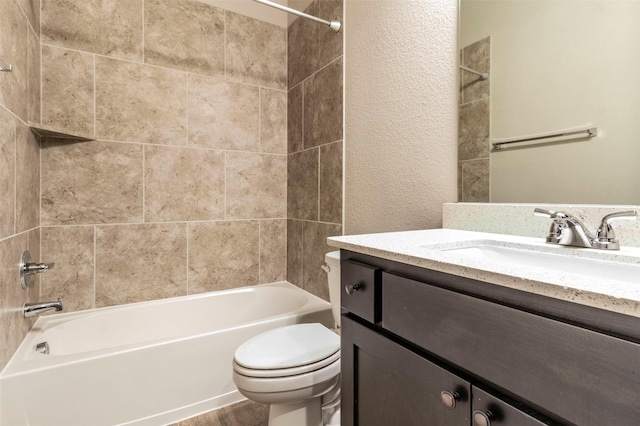 full bathroom featuring vanity, tiled shower / bath combo, and toilet