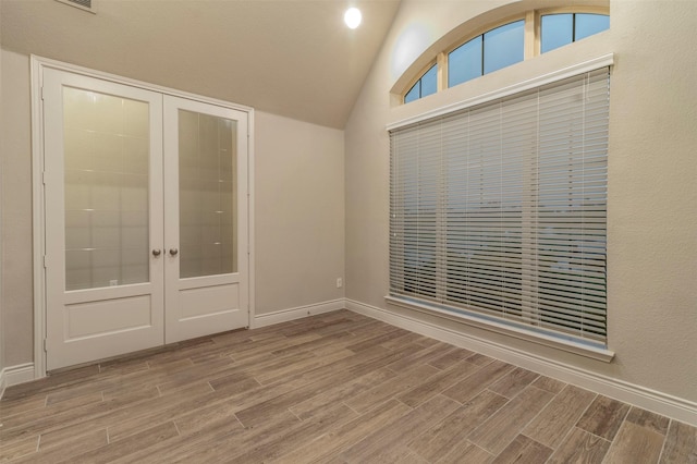 empty room with french doors and lofted ceiling