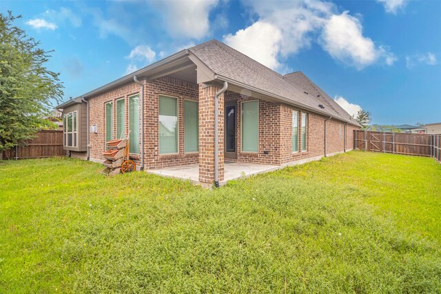 rear view of property with a patio and a lawn