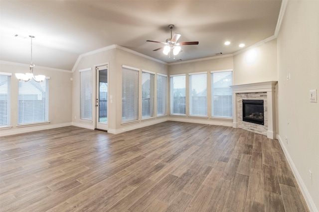 unfurnished living room featuring lofted ceiling, crown molding, hardwood / wood-style floors, and ceiling fan with notable chandelier