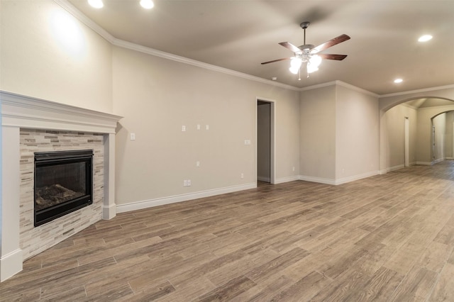 unfurnished living room with a tile fireplace, light hardwood / wood-style floors, ceiling fan, and ornamental molding