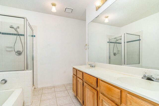 bathroom with tile patterned flooring, vanity, separate shower and tub, and a textured ceiling