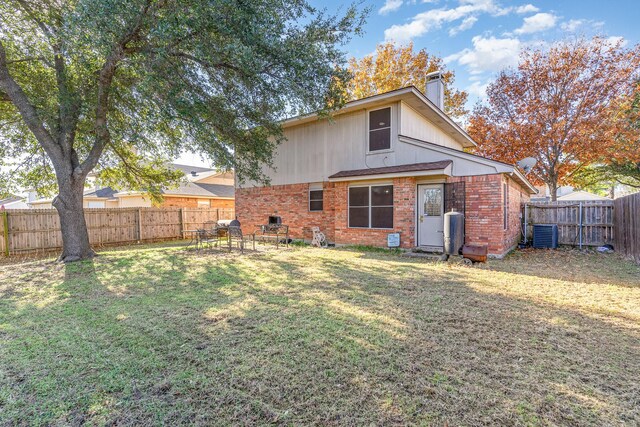 back of house with a lawn and central AC