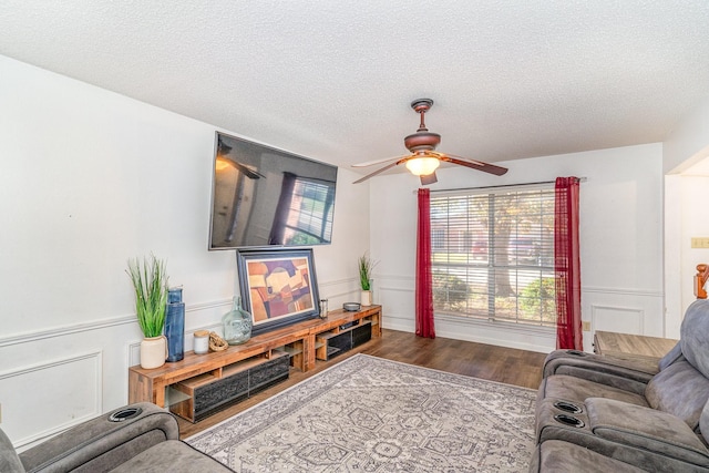 living room featuring ceiling fan, wood-type flooring, and a textured ceiling