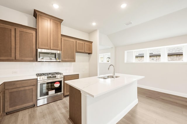 kitchen featuring decorative backsplash, brown cabinetry, visible vents, appliances with stainless steel finishes, and light wood finished floors