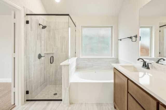 bathroom with vanity, a healthy amount of sunlight, a bath, and a stall shower