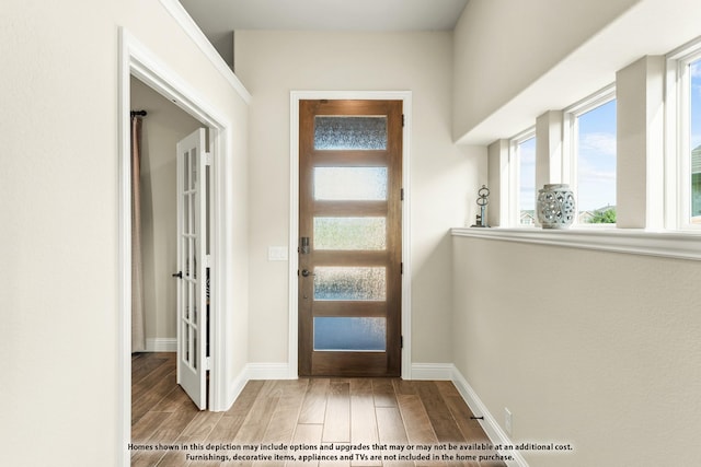 foyer entrance with french doors and light hardwood / wood-style floors