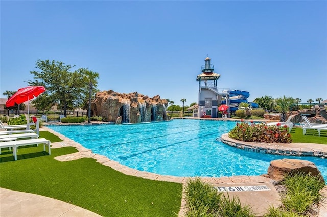 view of pool with a lawn and pool water feature