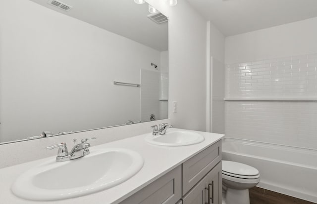 full bathroom featuring shower / bathing tub combination, hardwood / wood-style floors, toilet, and vanity