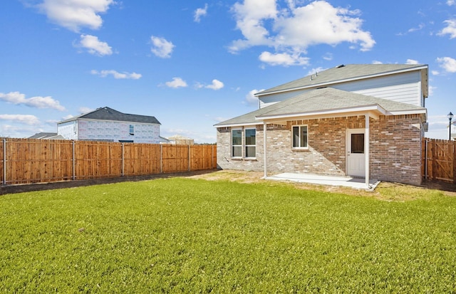 rear view of house featuring a patio and a yard