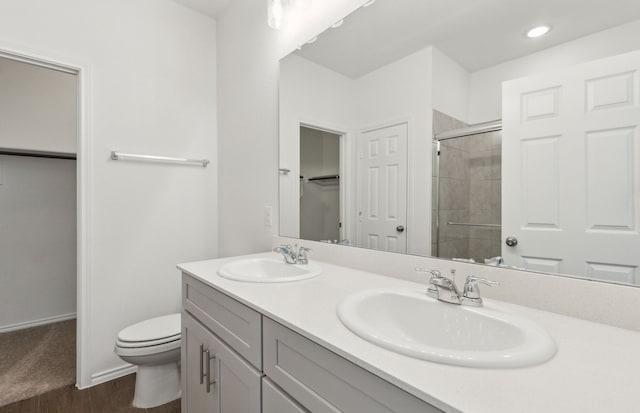 bathroom with vanity, toilet, a shower with shower door, and wood-type flooring