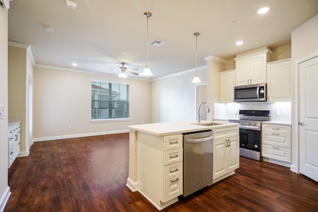 kitchen featuring sink, white cabinetry, a center island with sink, ornamental molding, and appliances with stainless steel finishes