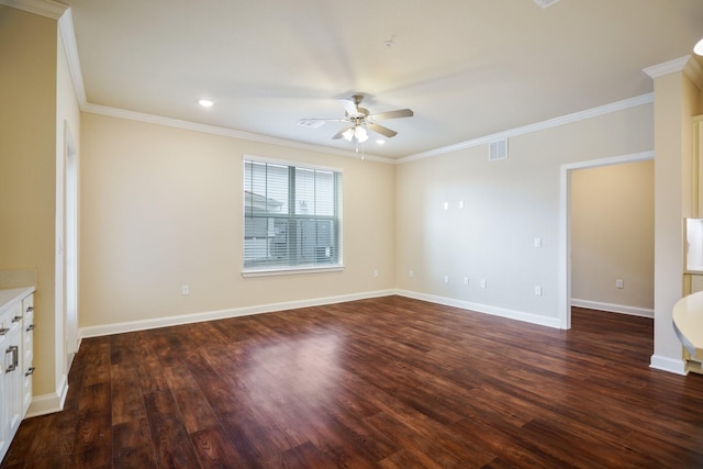 spare room featuring crown molding, dark wood-type flooring, and ceiling fan