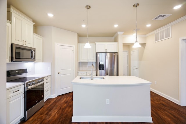 kitchen with appliances with stainless steel finishes, pendant lighting, white cabinetry, an island with sink, and sink