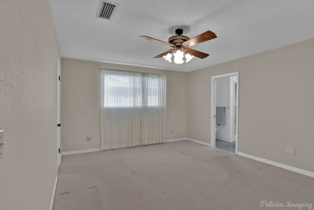 spare room featuring ceiling fan and light colored carpet