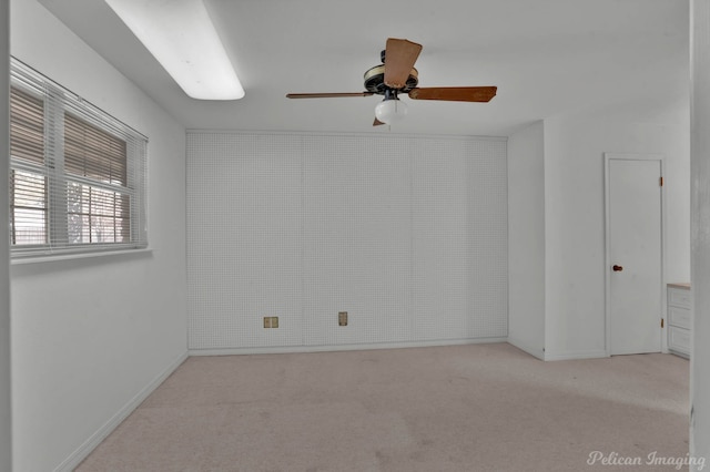 empty room featuring ceiling fan and light colored carpet