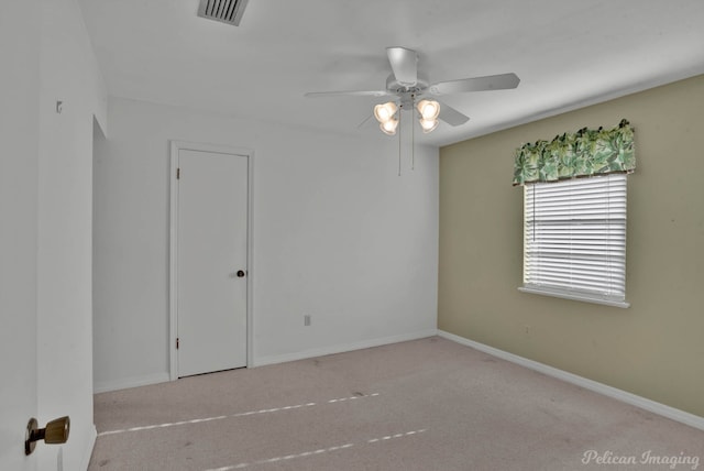 carpeted spare room with ceiling fan