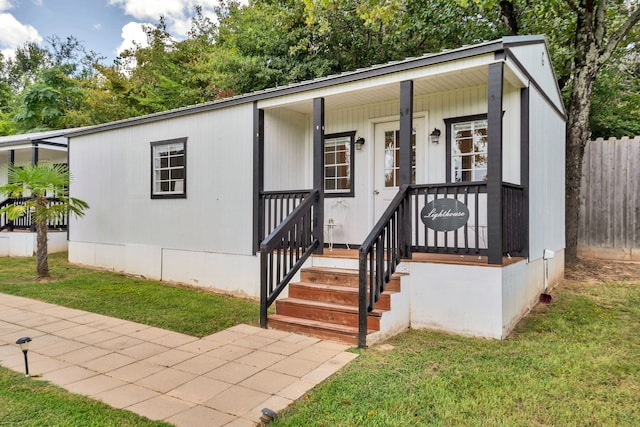 manufactured / mobile home with a front lawn and a porch