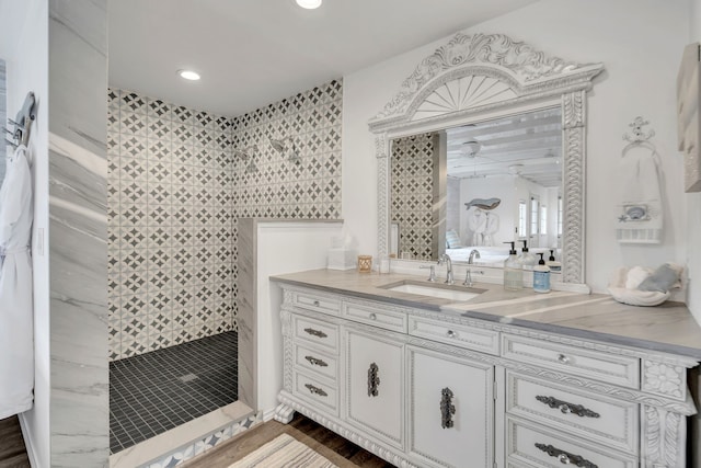 bathroom featuring tiled shower and vanity