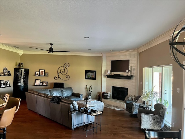 living room featuring crown molding, ceiling fan, dark hardwood / wood-style floors, and a brick fireplace