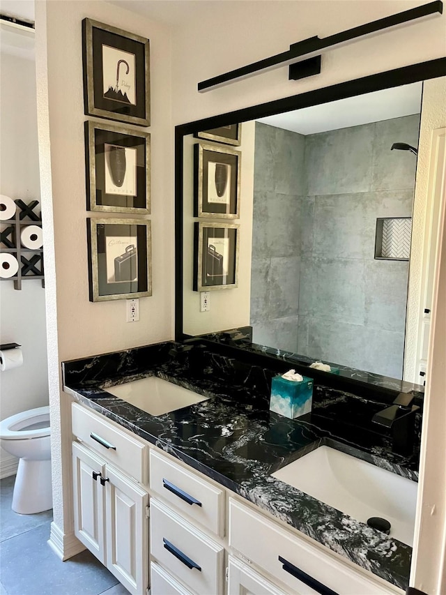 bathroom with tile patterned flooring, vanity, and toilet