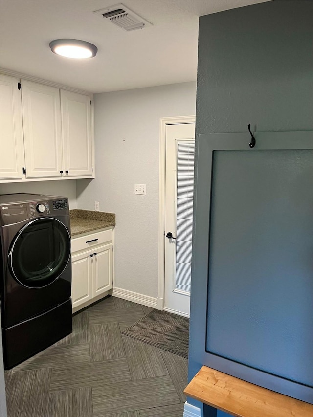 clothes washing area with cabinets and washer / clothes dryer