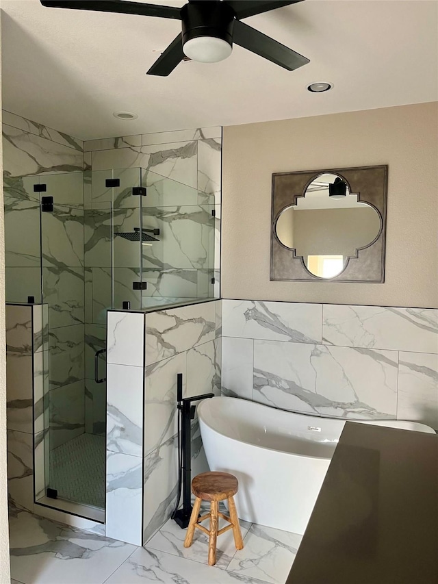 bathroom featuring separate shower and tub, ceiling fan, and tile walls