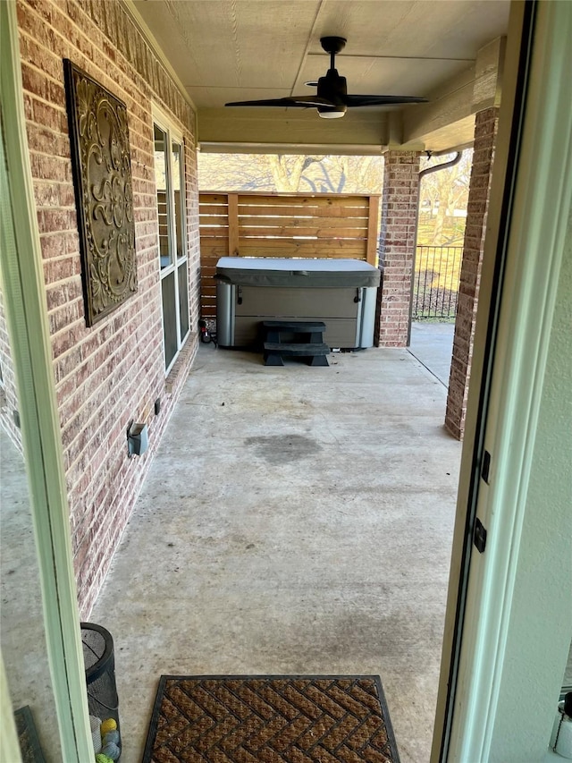 view of patio / terrace featuring ceiling fan, a porch, and a hot tub