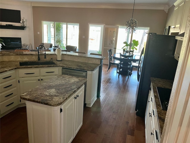 kitchen featuring a center island, sink, dark hardwood / wood-style floors, pendant lighting, and white cabinets