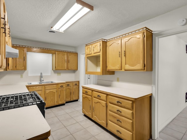 kitchen featuring sink, exhaust hood, a textured ceiling, and light tile patterned floors