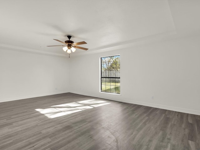 empty room with ceiling fan and dark hardwood / wood-style flooring