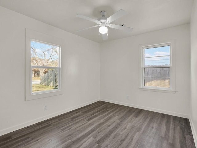 spare room featuring plenty of natural light, dark wood-type flooring, and ceiling fan