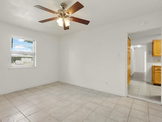 spare room with light tile patterned floors and ceiling fan