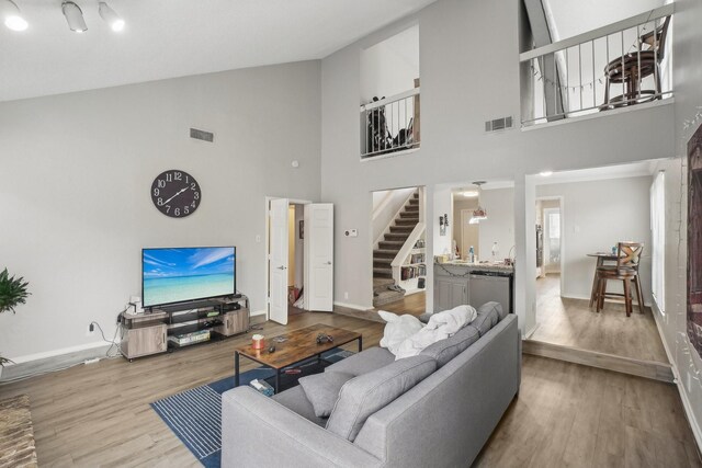 living room with high vaulted ceiling and light hardwood / wood-style floors