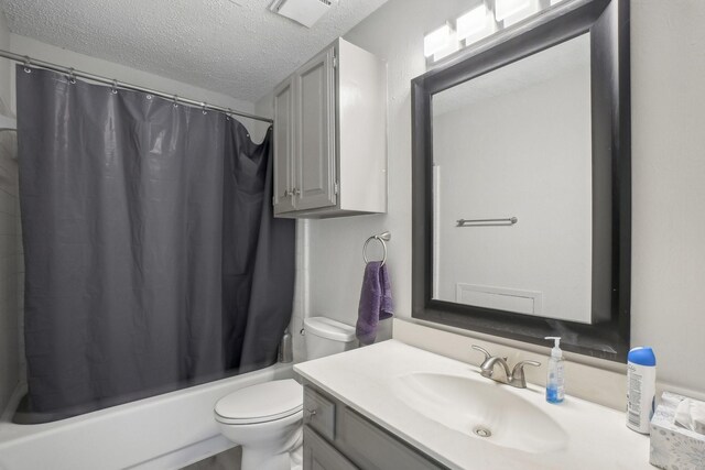 full bathroom featuring vanity, shower / tub combo, a textured ceiling, and toilet