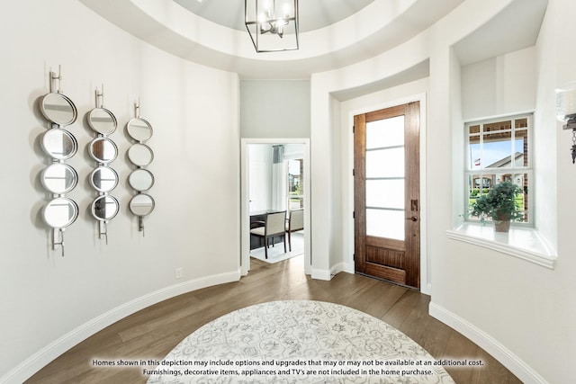 entryway with plenty of natural light, hardwood / wood-style floors, a chandelier, and a tray ceiling