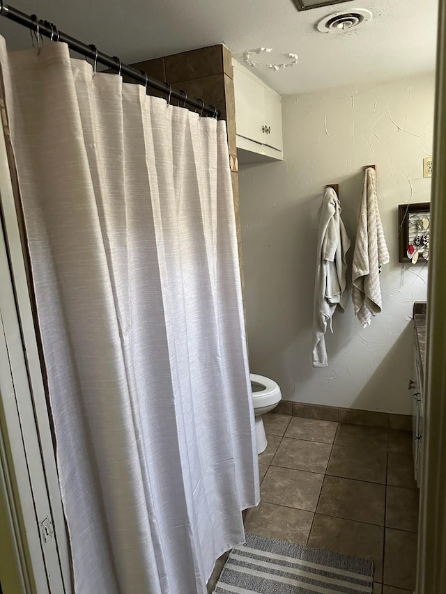 bathroom featuring toilet and tile patterned floors