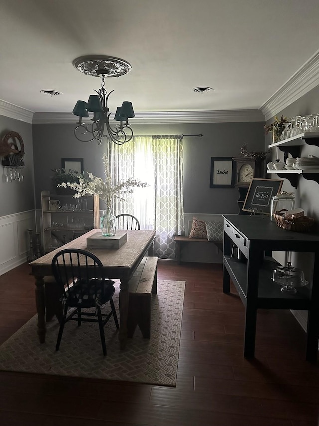 dining area with dark hardwood / wood-style floors, crown molding, and a chandelier