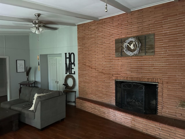 living room with ceiling fan, a fireplace, beamed ceiling, and dark wood-type flooring