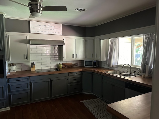 kitchen with dark hardwood / wood-style flooring, sink, stainless steel appliances, and wood counters