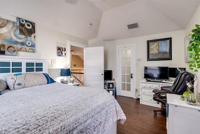 bedroom featuring vaulted ceiling, dark hardwood / wood-style floors, and a textured ceiling