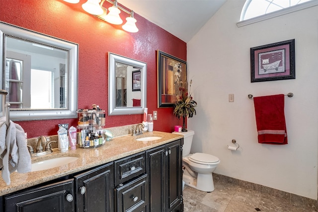 bathroom with vaulted ceiling, vanity, and toilet