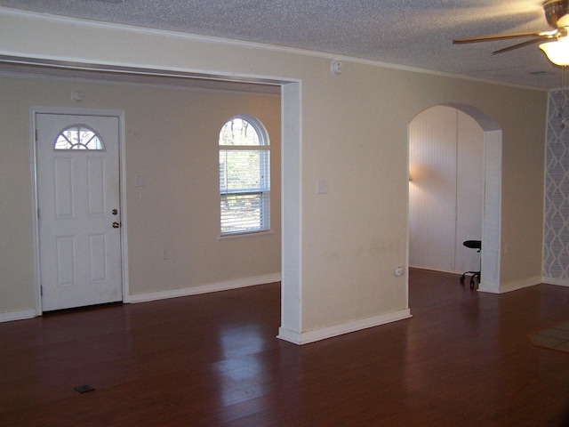 foyer entrance featuring dark hardwood / wood-style flooring, ceiling fan, ornamental molding, and a textured ceiling