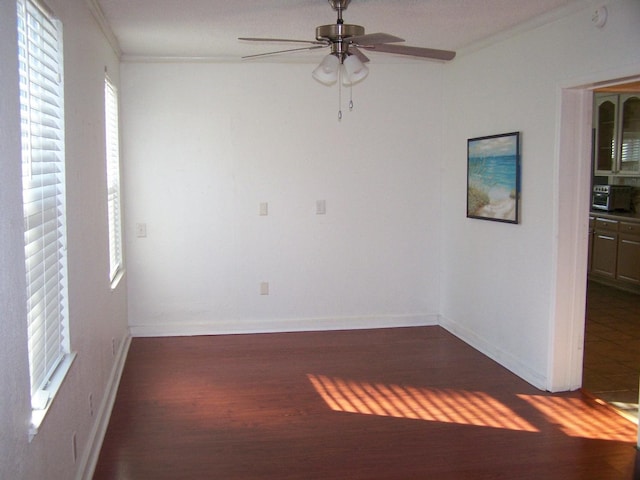 empty room featuring ornamental molding, dark hardwood / wood-style floors, and ceiling fan