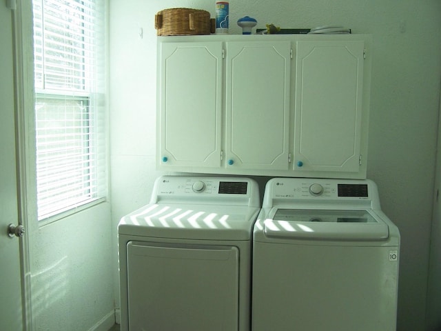 washroom with cabinets, separate washer and dryer, and a wealth of natural light