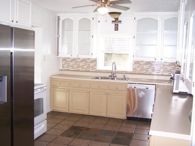 kitchen featuring decorative backsplash, a textured ceiling, stainless steel appliances, ceiling fan, and sink